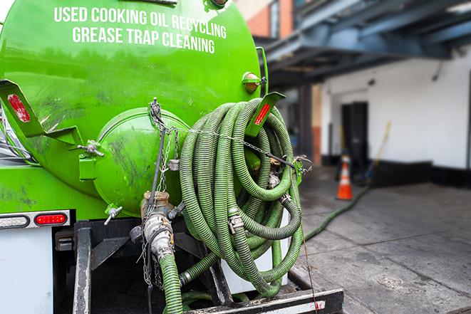 a technician pumping a grease trap in a commercial building in Antioch, TN